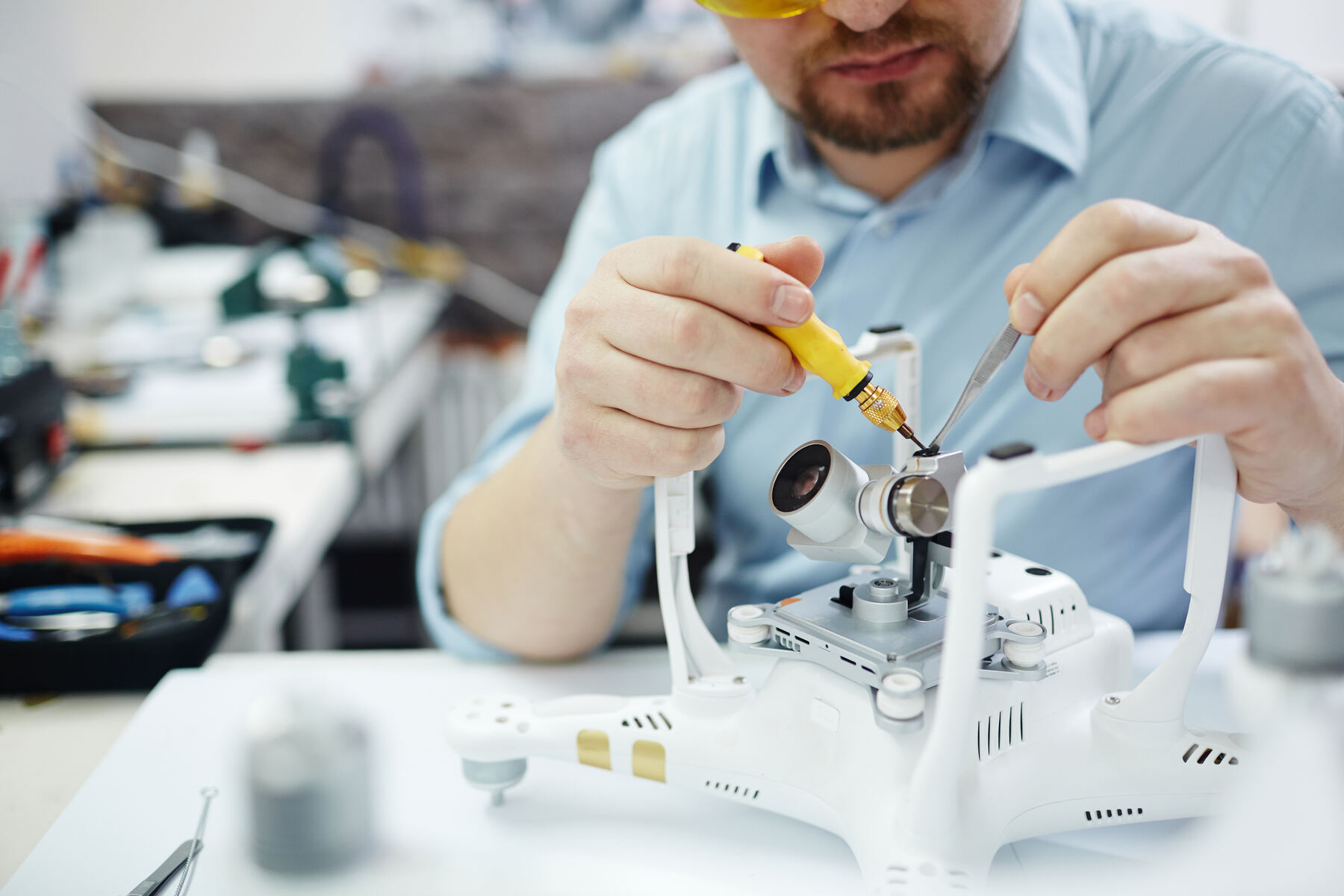 Tehnician asamblând componenta camerei unei drone
